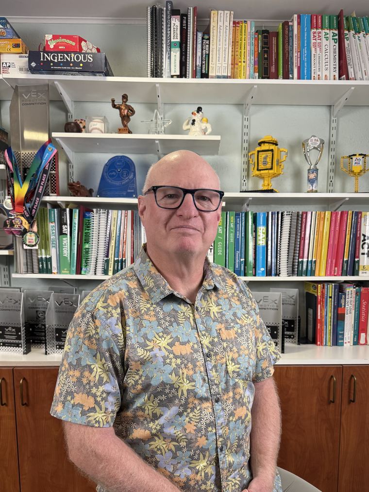 David Zook in his tutoring office, surrounded by test-prep books and student competition trophies